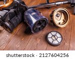 Small photo of disassembled bagless vacuum cleaner and it's parts - tube with HEPA - high efficiency particulate air - filter inside and cover, close-up with selective focus