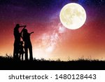 family standing on hill and watching the moon.Celebrate Mid-autumn festival together
