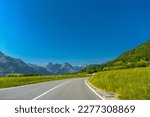 Road with green meadows and moutains near Haut-Intyamon, Gruyere, Fribourg Switzerland.