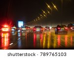 Motion blurred photograph of traffic at in night in the rain on a British motorway with police officer and car