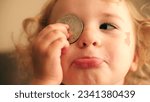 Small photo of Cute little girl plays with a bitcoin token or coin. Cryptocurrency noob concept