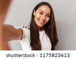 Image of excited happy young woman isolated over grey background make selfie by camera.