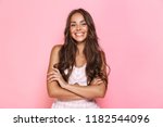 Image of european lovely woman 20s with long hair wearing dress smiling at you with arms crossed isolated over pink background
