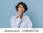 Small photo of White puzzlement woman wearing shirt frowning while looking aside isolated over blue background