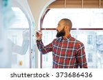 Profile of handsome african man with beard standing and writing on whiteboard