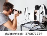 Photographer shooting model in studio with softboxes