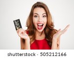 Happy excited amazed young woman holding credit card over white background