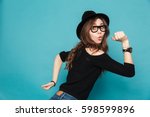 Portrait of a funny young cute girl in hat running isolated on the blue background