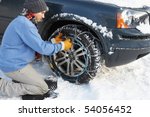 Man Putting Snow Chains Onto Tyre Of Car