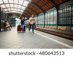 Small photo of The family rushes to the train. Mom drags two large suitcases. Pope carries both children. Parents hotfoot. Children laugh. Several passengers sit on the bench.