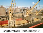 Small photo of ODESSA, UKRAINE - August 9, 2021: Loading grain into holds of sea cargo vessel through an automatic line in seaport from silos of grain storage. Bunkering of dry cargo ship with grain