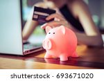pink color Pig save bank with woman holding credit card using internet computer on background, money discount saving shopping on line concept.