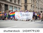 Small photo of 2018 JUNE 24 NEW YORK: NYC Pride March participants walk behind a Outright Action International banner on the 5th Ave parade route.