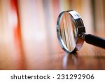 Close up Single Magnifying Glass with Black Handle, Leaning on the Wooden Table at the Office.