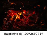 Small photo of Sparks of fire on a black background. flame of fire with sparks. Burning red hot sparks fly from hot coals in the fire. Beautiful abstract background on the theme of fire, light and life.
