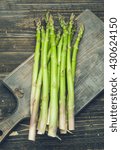 Small photo of bunch of asparagus, on lackluster wooden board