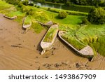 Small photo of Aerial drone view of silt filled hulks of abandoned boats used to reduce erosion on the banks of the River Severn in England (Purton Hulks)