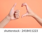 The two hand of Asian man connected each other with heart sign and thumb up sign on the pink background.