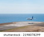 Small photo of White aiplane landing in Madeira airport, runaway above Atlantic ocean