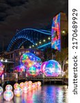 Small photo of Sydney, Australia - June 15, 2022: Ephemeral Oceanic, Vivid Sydney installation at Walsh Bay with Harbour Bridge.
