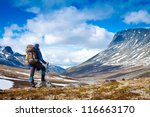 Tourist with a backpack and mountain panorama