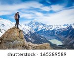 hiker at the top of a rock with backpack enjoy sunny day 