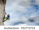 Young Male Climber Hanging By A ...