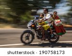Small photo of KERALA, INDIA - FEBRUARY 17: Young family riding on a bike (blurred motion). Motorbike is the most favorite vehicle and most affordable for India.