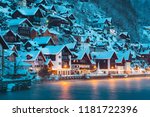 Panorama view of famous Hallstatt lakeside town in the Alps in mystic twilight during blue hour at dawn on a beautiful cold foggy day in winter, Salzkammergut region, Austria