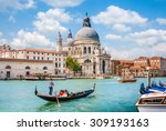 Beautiful view of traditional Gondola on Canal Grande with Basilica di Santa Maria della Salute in the background on a sunny day in Venice, Italy