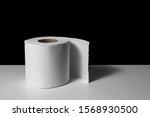Small photo of toilet paper is consider a must item during crisis. tissue roll on white table with black background for copyspace.