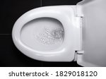Small photo of The white flush toilet bowl that the water is draining. concept of flushing away something.