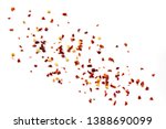 Hot chilli flakes scattered over white background, top view.