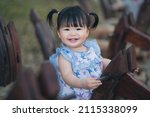 Small photo of Happy cute baby playing on rocking horse in the park. 1 year 6 month baby in the park use as concept of play, health, mood and motion of baby and kid development.