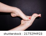 Two Caucasian female dancer's feet with red pedicure are touching each other isolated on black background