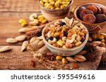 Mix of nuts and dried fruits on a old rustic table. Gold pistachios, cashews, hazelnuts, almonds.
