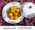 Small photo of Traditional oriental dessert speciality called luqaimat, fried dough balls in a plate being drizzled with dibs (date syrup). Luqaimat is a popular Arabian dessert that is often eaten during Ramadan.