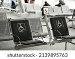 Seats reserved for persons with disabilities inside an airport terminal.