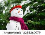 Small photo of Poetry snowman. Close up photo with a snow man build in the court yard against green trees, dressed in literature style with glasses, scarf and bonnet.