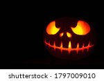 Small photo of Ghastly Halloween pumpkin head jack lantern on black background