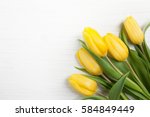 Yellow tulips on white wood background. Spring - poster with free text space.
