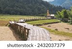 Small photo of PHRAE , THAILAND - DEC 4 , 2023 : A bamboo bridge to Phra Chao Ton Luang a large outdoor golden Buddha statue. Sitting in the middle of a rice field at Wat Nakhuha there are beautiful natural places.