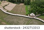 Small photo of Top view of the bamboo bridge to the village. Passing through the middle of rice fields is a beautiful natural place. Located in Phrae Province, Thailand.