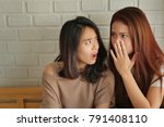 Small photo of disappointed surprised excited woman gossiping, whispering, listening to rumor or hearsay concept, women or girls consulting saying, discussing something in secret, April fool's day concept