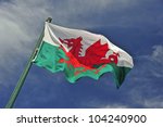 The Welsh Flag Against A Blue...