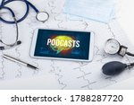 Tablet pc and medical tools with PODCASTS inscription, social distancing concept