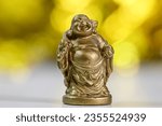 Close up view of Laughing Buddha statue  against golden background.