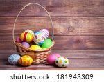 Easter eggs in the basket of wooden boards