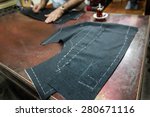 A tailor's work table with  cloth for a jacket cut and marked up for sewing. (SELECTIVE FOCUS)