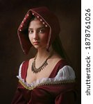 Small photo of Portrait of a gorgeous girl in medieval time dress and headdress.